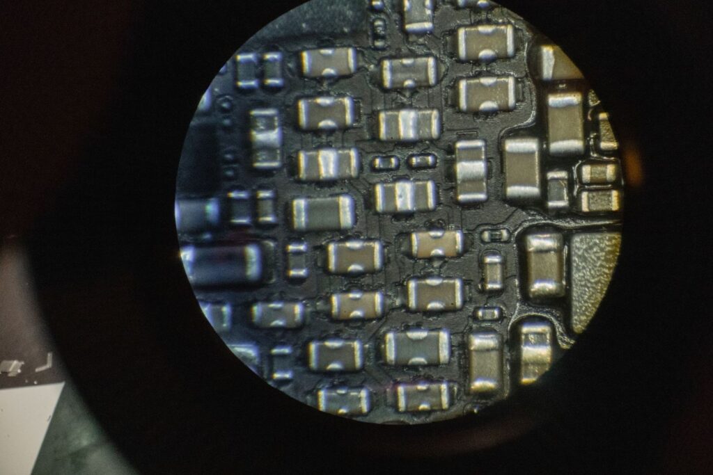 Vue au microscope d’un circuit imprimé couvert de composants électroniques
